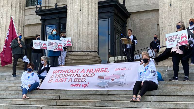 MNU President Darlene Jackson speaks beside a hospital bed at the top of the Legislature during CFNU's National Day of Action.